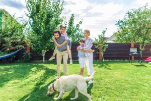 Happy family enjoying time outdoors with Labrador dog in a clean backyard